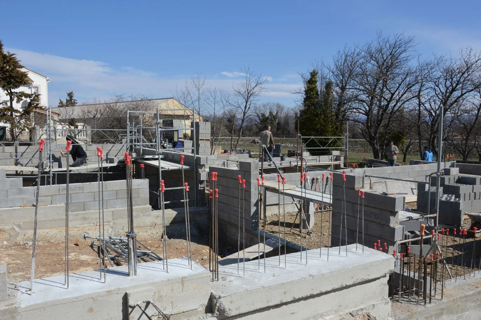 Chantier de construction d'une maison individuelle avec murs en parpaings et échafaudages