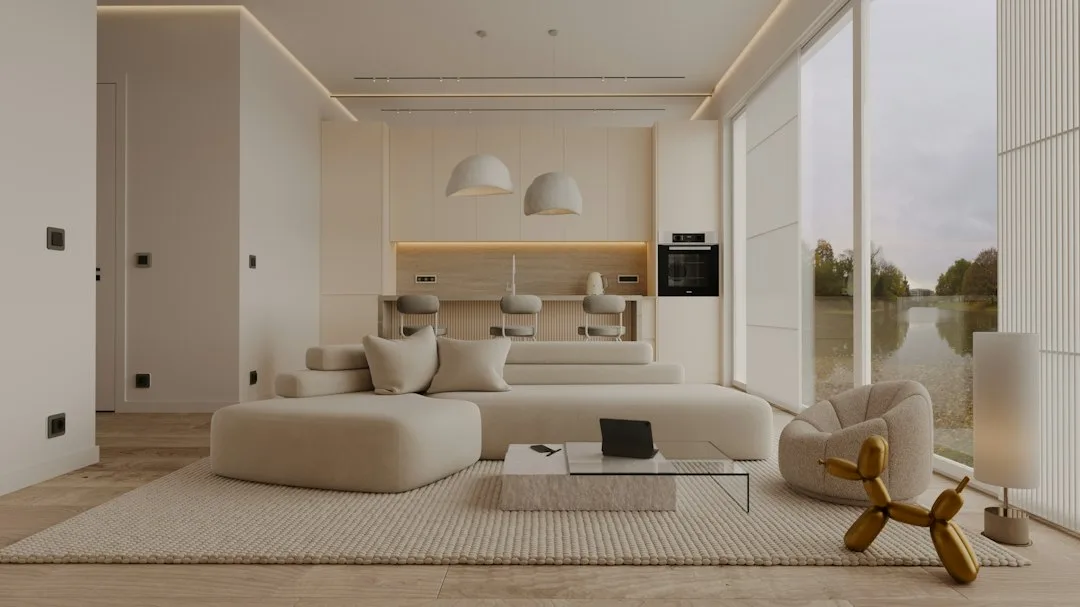 Pièce de vie minimaliste ouverte sur la cuisine, avec grandes baies vitrées et mobilier épuré